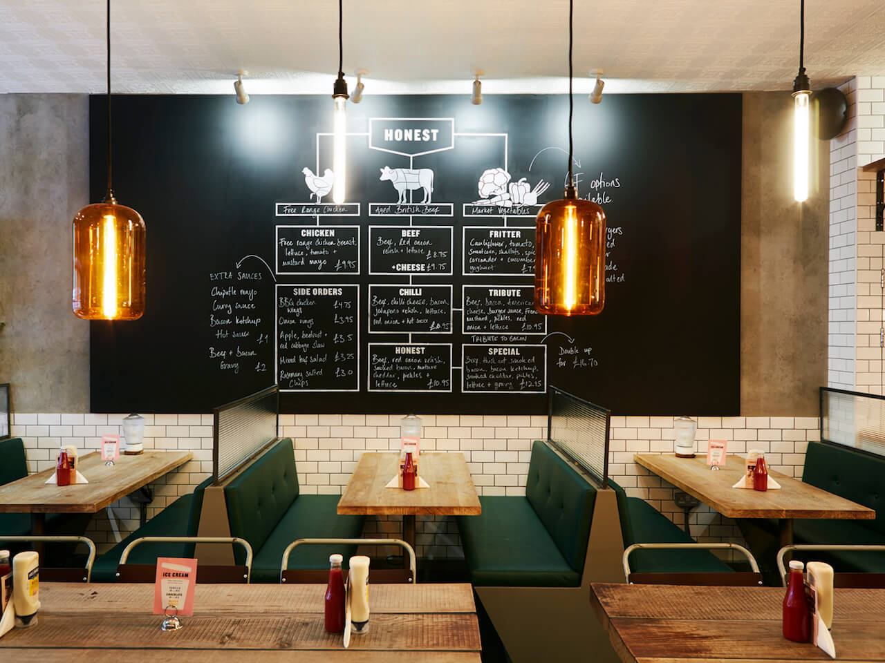 Booth seating and large blackboard menu inside Honest Burgers Ealing