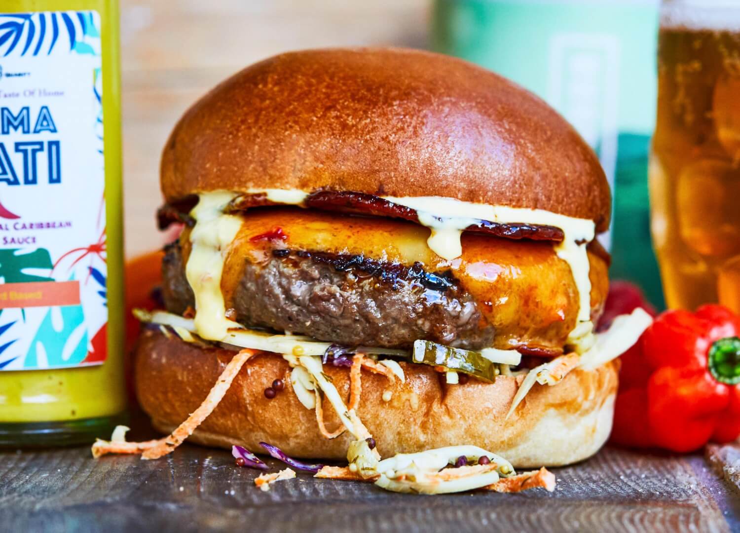Beef burger with candied bacon, chilli cheese, mama nati hot sauce mayo and carribean slaw
