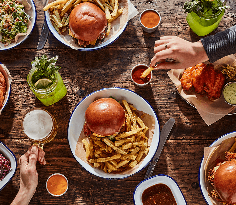 Burgers on table with hands